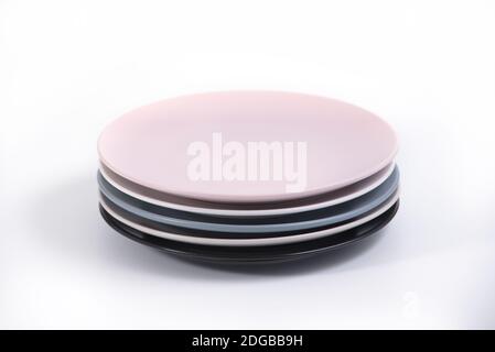 Stack of five colorful empty plates isolated on white background, side ...