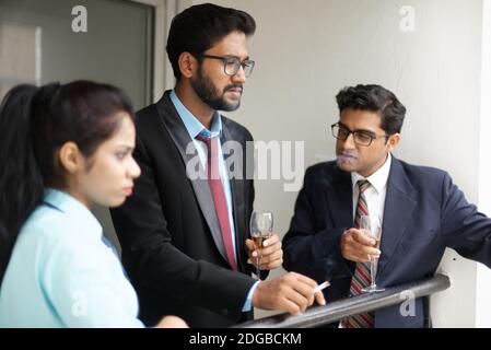 Corporate meetings between young and energetic Indian Bengali bosses/officers/managers and secretary at window of the office building. Stock Photo