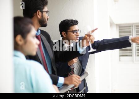 Corporate meetings between young and energetic Indian Bengali bosses/officers/managers and secretary at window of the office building. Stock Photo