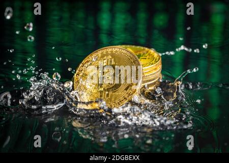 Gold bitcoin coin falling to water. Bitcoin and water splash. Stock Photo