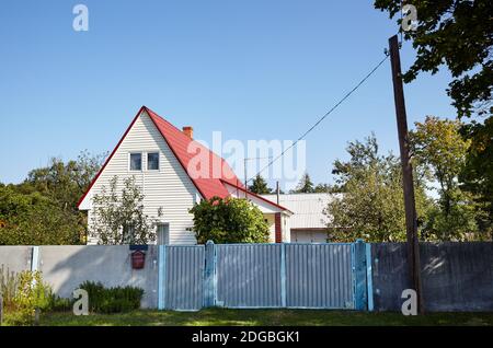 Facade of a European suburban building. Wall of small house against a blue sky Stock Photo