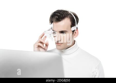 Cyborg in eye lens and headphones looking at computer on blurred foreground isolated on white Stock Photo