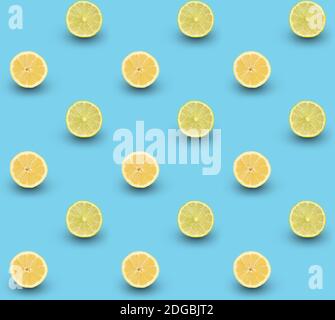 Repeated seamless pattern of many sliced ripe lemons and limes on light blue background. Stock Photo