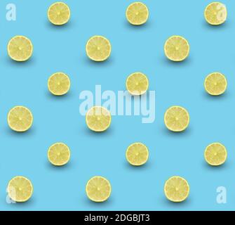 Repeated seamless pattern of many sliced ripe limes on light blue background. Stock Photo