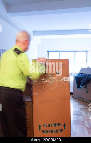 Senior man unpacking in his new apartment in New York City, USA Stock Photo