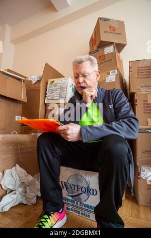 Senior man unpacking in his new apartment in New York City, USA Stock Photo