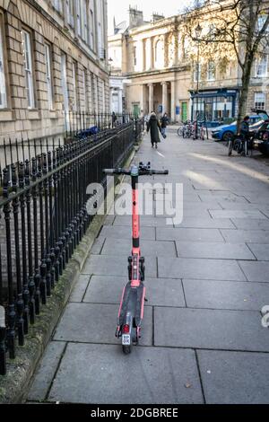 Single electric scooter  for hire - parked on pavement beside road in Bath, Somerset, UK on 8 December 2020 Stock Photo