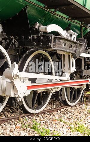 Old locomotive big wheels of iron with a white rim stands on the paths close-up Stock Photo