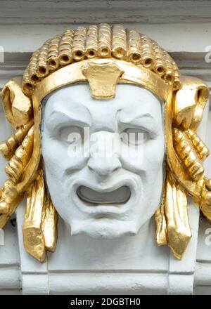 Ornamental detail and architectural element of theatrical mask depicting man's face with golden details on theatre building facade in Sofia Bulgaria Stock Photo