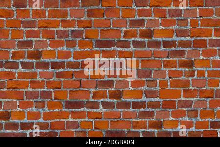 Masonry bricks with cement uneven stripes red background wallpaper Stock Photo
