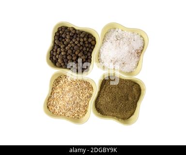 Four ceramic green bowls with fragrant pepper salt and garlic cardamom on a white background Stock Photo