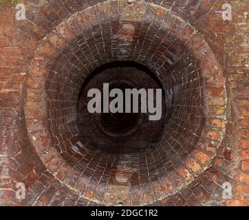 Dark long corridor lined with bricks old passage into the network of tunnels Stock Photo
