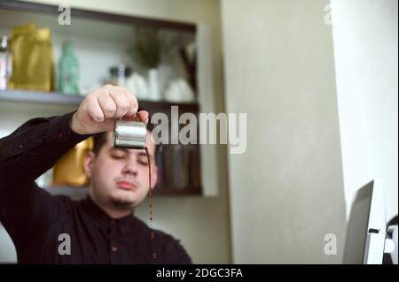 emphasis on droplets of coffee pouring from the container in the hands of young baristas Stock Photo