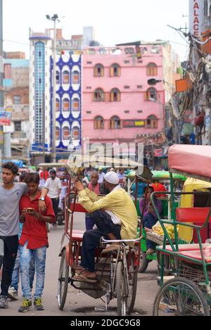 Indian rickshaw driver waiting for business in a busy street, Old Delhi, India Stock Photo