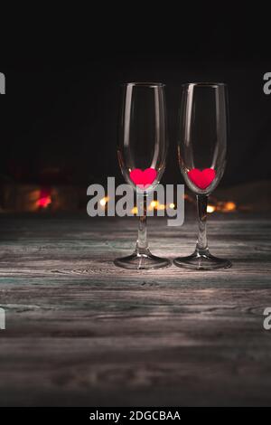 Empty wine glasses with red hearts on a brown background. Stock Photo