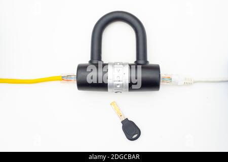 Two computer network cables going through a lock with a key Stock Photo