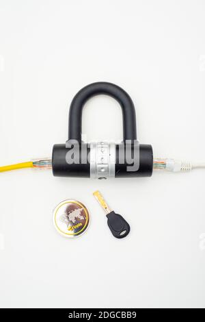 Two computer network cables going through a lock with a key and a crypto currency coin Stock Photo