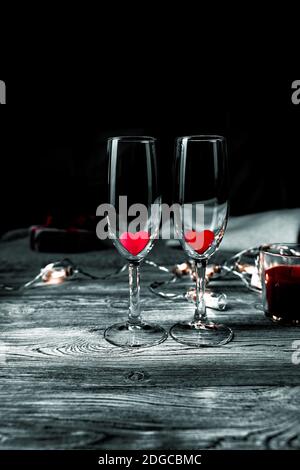 Two glasses with red hearts inside on a black background. Stock Photo