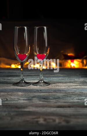 Champagne glasses with red hearts on a dark background. Stock Photo