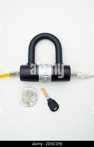 Two computer network cables going through a lock with a key and a crypto currency coin Stock Photo