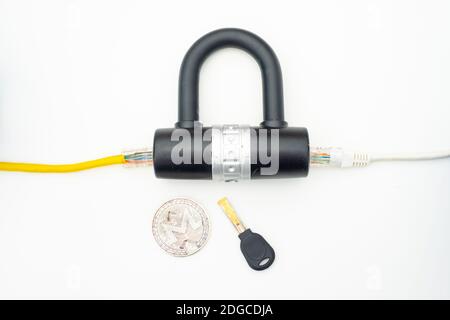Two computer network cables going through a lock with a key and a crypto currency coin Stock Photo