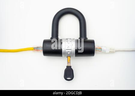 Two computer network cables going through a lock with a key Stock Photo