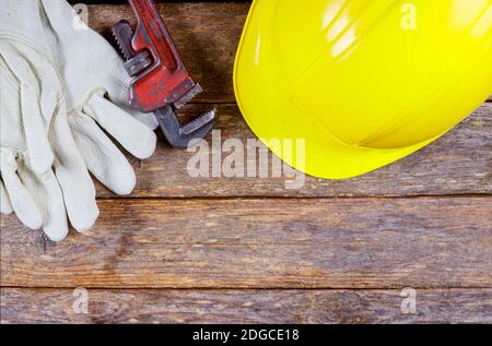 Working gloves, building helmet and glasses, tool equipment on wood table Stock Photo