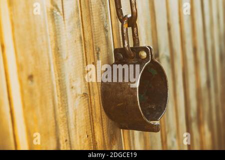 Old handcuffs old traditional metal large hang on wooden stained background Stock Photo