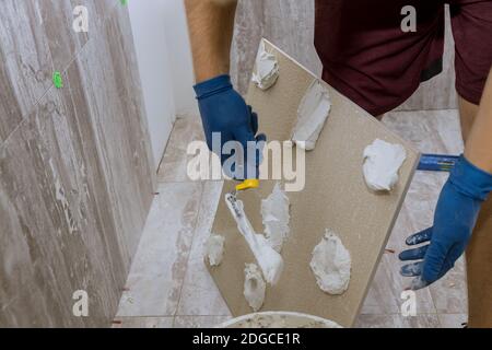 Spreading wet mortar before applying tiles on bathroom floor Stock Photo
