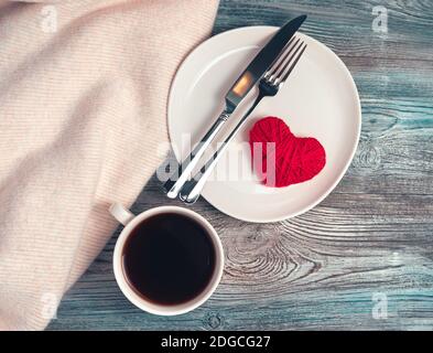 Romantic background with coffee Cup, plate, heart and Cutlery on natural wood. Stock Photo