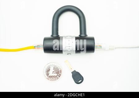 Two computer network cables going through a lock with a key and a crypto currency coin Stock Photo