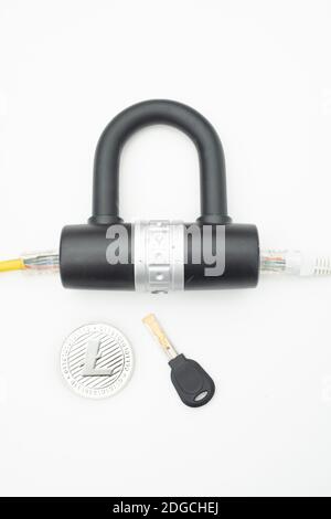Two computer network cables going through a lock with a key and a crypto currency coin Stock Photo