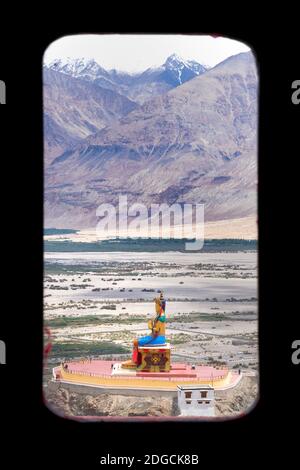 The large statue of buddha opposite Deskit monastery. The monastery is ...