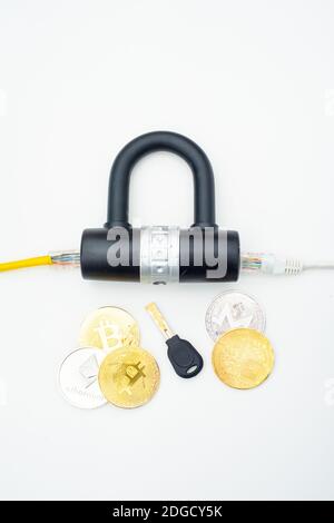 Two computer network cables going through a lock with a key and a crypto currency coin Stock Photo