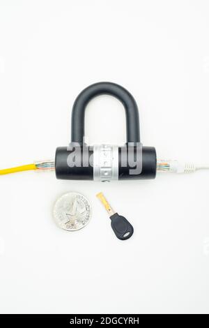 Two computer network cables going through a lock with a key and a crypto currency coin Stock Photo
