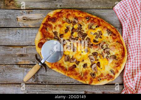 Homemade mushrooms pizza with cutter and towel. Stock Photo