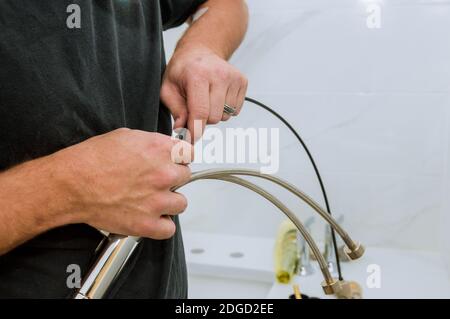 Installation of chrome faucet plumber at work in a bathroom Stock Photo