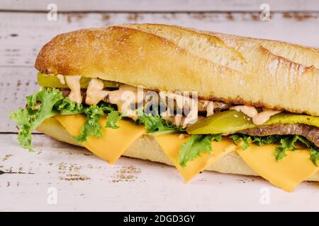Sub sandwich with cheese and pickles on a white background. Stock Photo