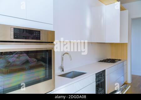 Interior of modern kitchen with appliances on stove top, marble counter with kitchen white cabinets Stock Photo