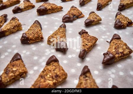 Triangle Nut Cookies Filled With Jam With The Ends Dipped In Dark Chocolate On Withe Baking Paper Stock Photo