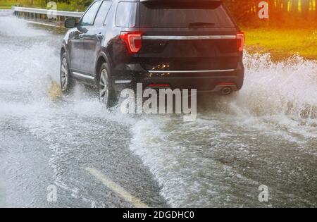 Cars driving on a flooded road during a flood caused by heavy rain, Stock Photo