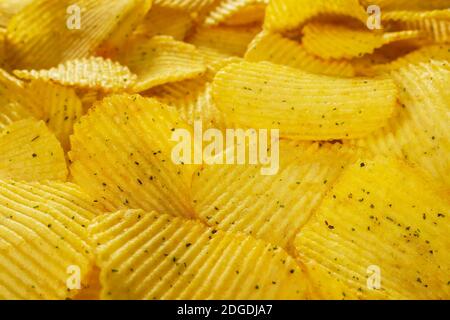 Potato fluted chips with spices, natural product close-up. Delicious background. Text on top of the image. Fast food. Stock Photo