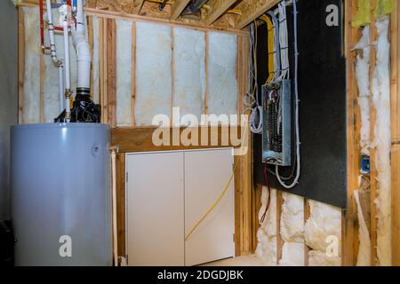 Household boiler house with heat wired electrical terminals on metal bar wall insulation in wooden house, building under constru Stock Photo