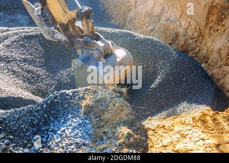Industrial machinery construction site, excavator moving gravel and rocks for foundation building Stock Photo
