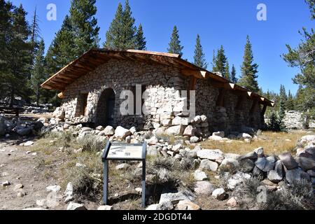 Parsons Lodge, A stone and wooden hut structure in Tuolumne Meadows, Yosemite National Park, USA. A sign with information for visitors stands outside. Stock Photo