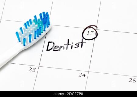 Dentist appointment reminder on calendar with toothbrush. Concept of oral health, exam and teeth cleaning Stock Photo