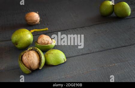 Walnuts in a green shell on a wooden table Stock Photo