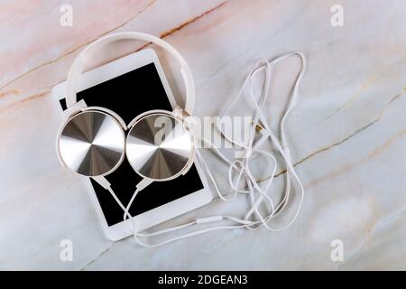 Tablet on marble background with headphone Stock Photo