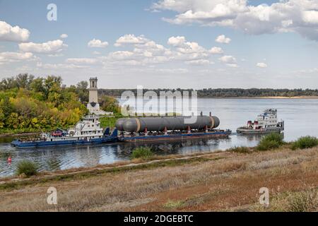 Transportation of large tanks for petrochemical enterprises on river with help of two tugs Stock Photo