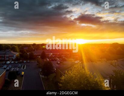 Aerial top down view flying over appartments in small town showing neighborhood early sunrise Stock Photo